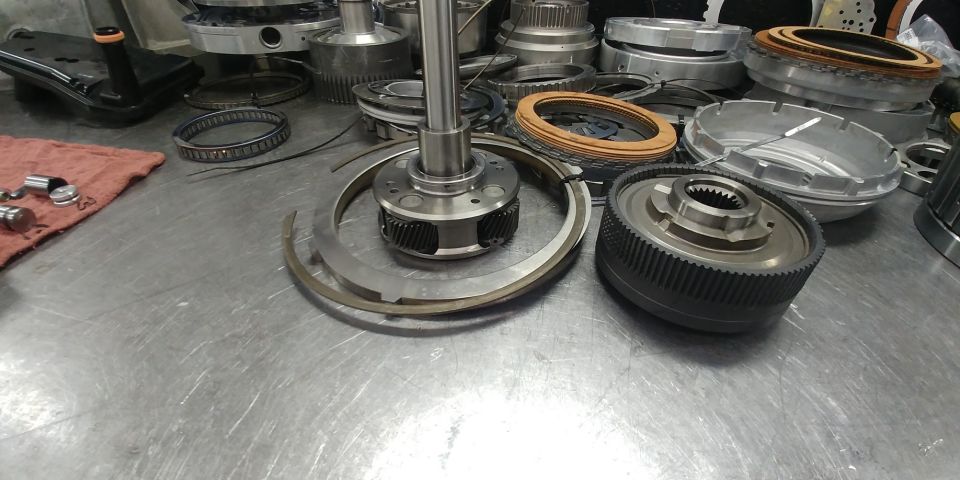 Disassembled transmission components on a metal workbench