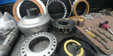 1996 Ford Bronco - Assorted internal components of an automatic transmission are displayed on a work surface.
