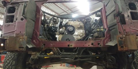 1996 Ford Bronco - The engine bay of a red SUV is shown, with the engine and chassis components exposed for work.