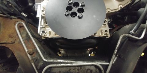 1996 Ford Bronco - Underside view of an engine component, likely a flywheel or clutch assembly, with surrounding mechanical parts.