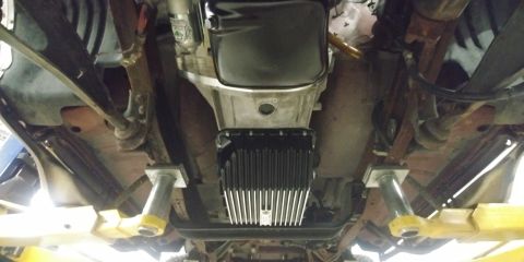 1996 Ford Bronco - The underside of a vehicle is shown, with focus on the transmission and exhaust components.