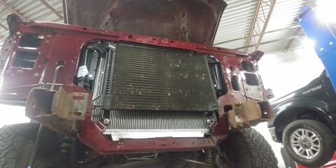1996 Ford Bronco - The front end of a red 1992 Ford Bronco is disassembled, revealing the radiator and other engine bay parts.