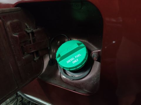 1996 Ford Bronco - Close-up of a vehicle's fuel filler area, showing a green cap indicating diesel fuel.