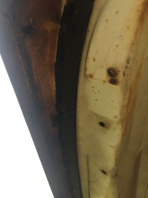 1962 Ford Galaxie - This image shows the heavily rusted seam of a car's body panel, indicating significant wear and tear.