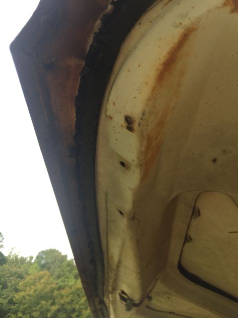 1962 Ford Galaxie - Close-up view of the underside of a car hood, revealing rust and wear.