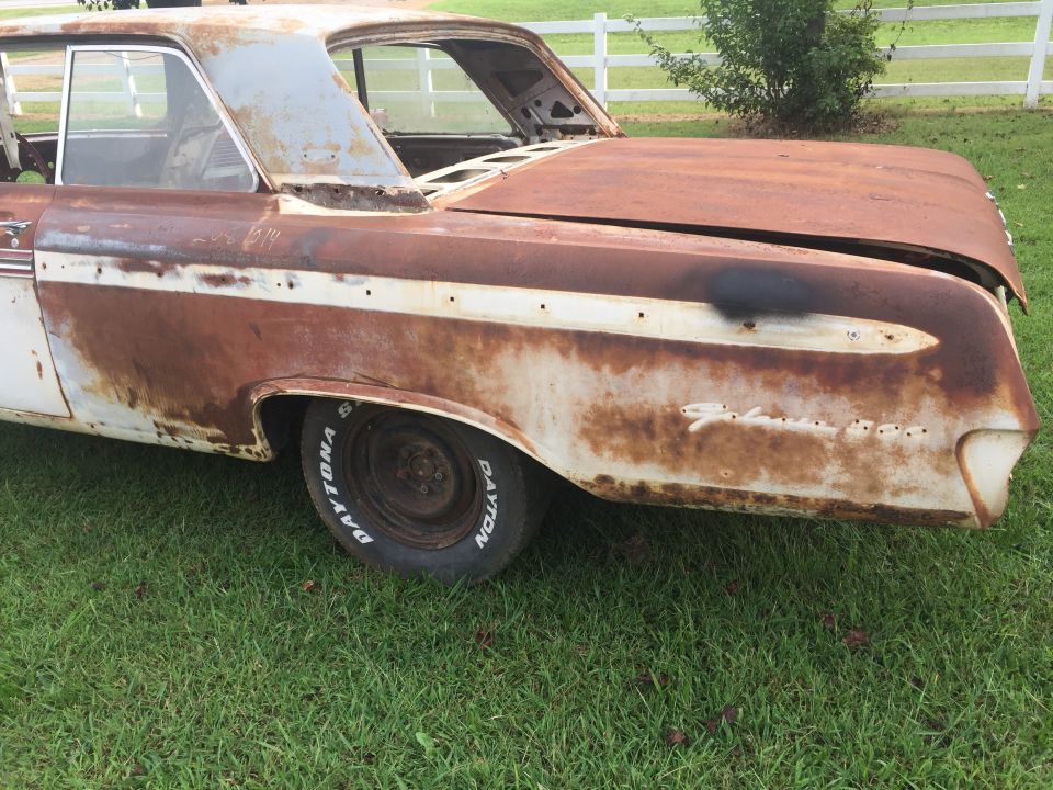 1962 Ford Galaxie rear quarter panel with rust and a white stripe