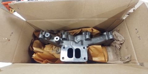1996 Ford Bronco - New exhaust manifold part, part number 3901646, is shown inside its shipping box.