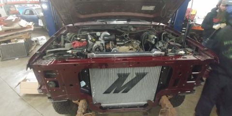 1996 Ford Bronco - The front end of a Ford truck is disassembled, revealing the engine and a large aftermarket radiator.