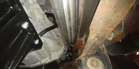 1996 Ford Bronco - Close-up view of a vehicle's undercarriage, showing mechanical components and signs of wear.