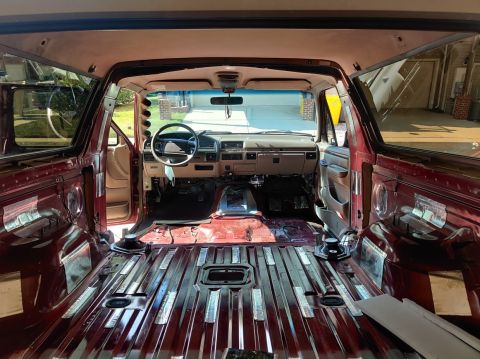 1996 Ford Bronco - The interior of a Ford Bronco is shown with seats removed, revealing the floor and dashboard.