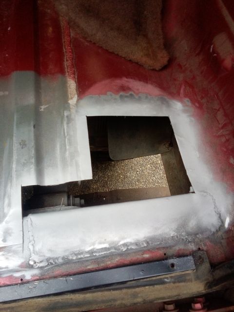 1994 Ford Bronco - Repair work on a vehicle's floor pan, showing a cut-out and filler application.