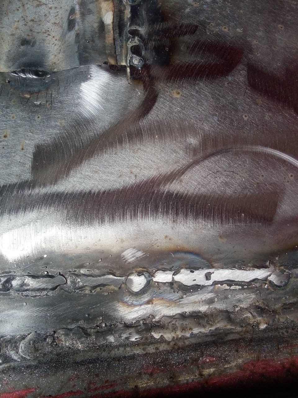 Welded metal with grinding marks and some rust