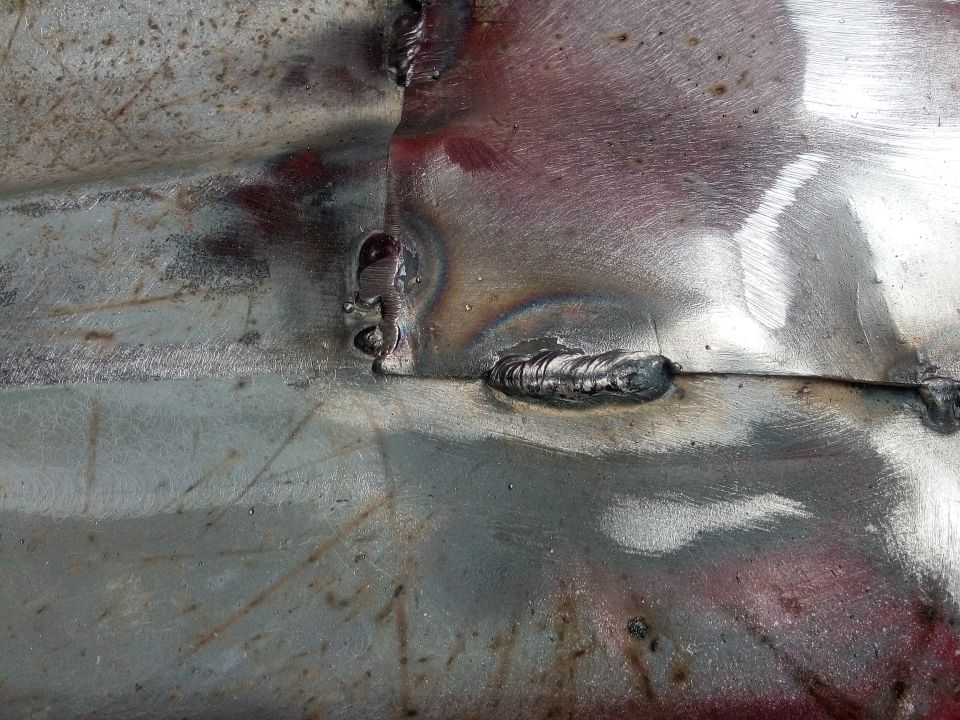 Close-up of welded metal panel with visible weld beads