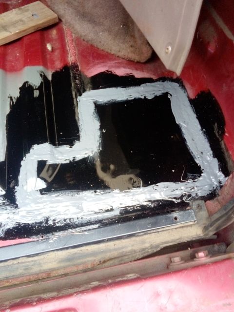 1994 Ford Bronco - Floor pan rust repair in progress with sealant and primer applied.