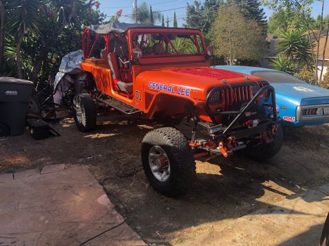1992 Jeep Wrangler - A bright orange Jeep Wrangler, nicknamed "General Lee" with the number "01" on the side, is parked outdoors next to a blue classic car. The…