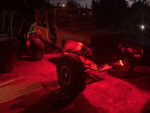 1992 Jeep Wrangler - A modified Jeep Wrangler, painted orange and black, is parked outdoors at night with bright red underglow lighting. The text "GENERAL LEE"…