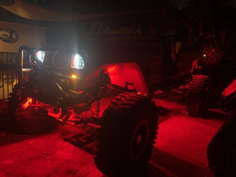 1992 Jeep Wrangler - A modified Jeep Wrangler, nicknamed "General Lee", is parked outdoors at night, illuminated by red accent lighting and its own headlights.…