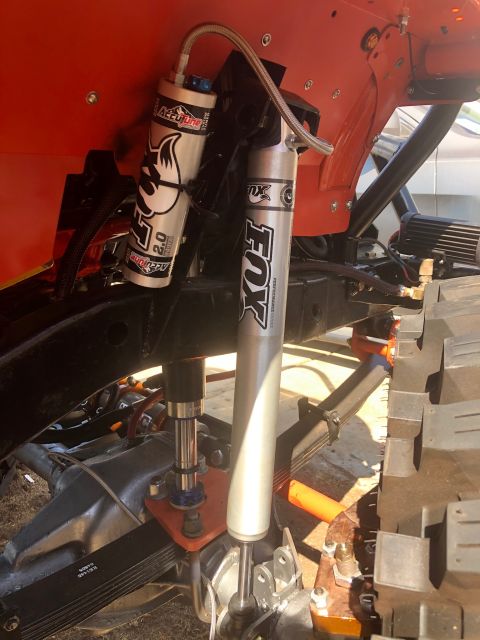 1992 Jeep Wrangler - A close-up view of the suspension system of an off-road vehicle, featuring two silver Fox Performance Series shocks with reservoirs. The sh…