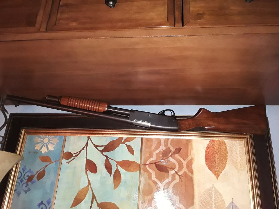 A wooden shotgun resting on top of artwork.