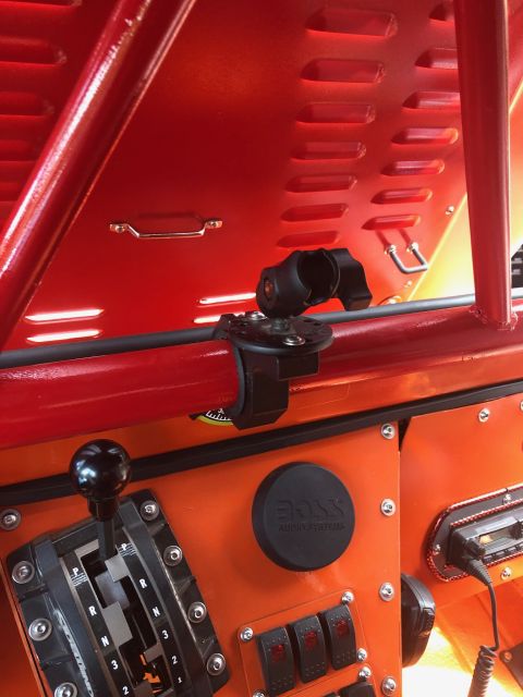 1992 Jeep Wrangler - The interior of a vehicle features an orange dashboard with a black gear shifter and a black round BOSS Audio Systems emblem. A black RAM m…