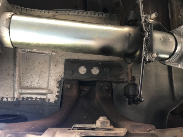 Underside of vehicle showing shock absorber and linkage rod.