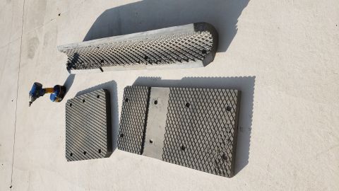 1965 Ford Mustang - Three diamond plate textured rubber mats and a cordless impact driver are laid out on a concrete surface. One mat is curved and appears to…