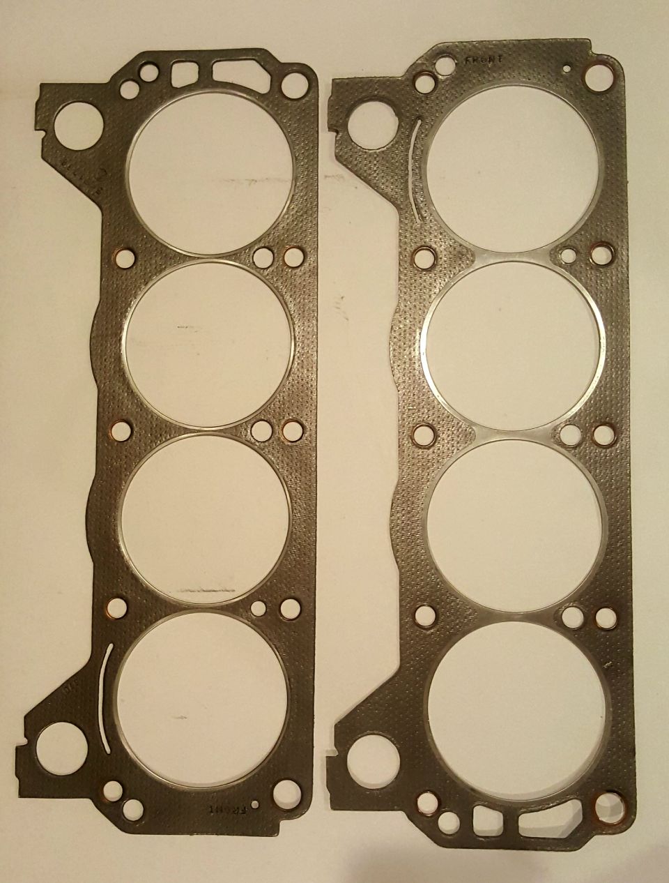 Two engine head gaskets with visible text.