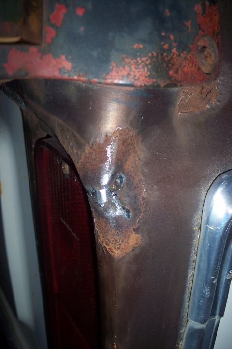 1978 Ford Bronco - This close-up photo shows a rusted metal corner of a vehicle, likely the rear quarter panel near a taillight. Welds are visible on the rust…