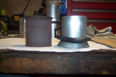 1978 Ford Bronco - Two metal pipe fittings are displayed on a white cloth. One is rusty and cylindrical, while the other is shiny metal with a flared base and…