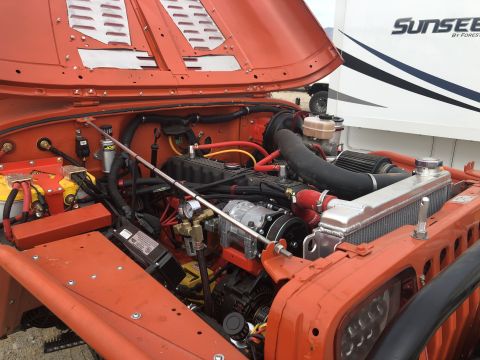 1992 Jeep Wrangler - Engine bay of a 1992 Jeep Wrangler, showing the engine and various aftermarket components.