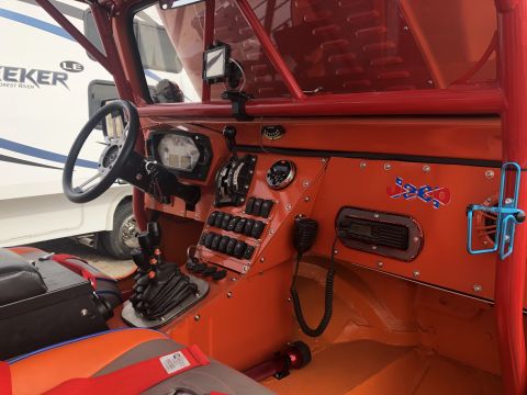 1992 Jeep Wrangler - Custom off-road vehicle interior features a roll cage, racing seats, and a dashboard with many switches and a CB radio.