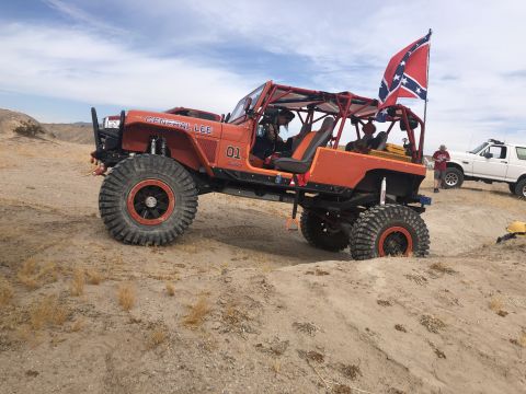 1992 Jeep Wrangler - This heavily modified Jeep, labeled "GENERAL LEE 01", flies a Confederate flag while navigating sandy terrain, with another SUV visible in…