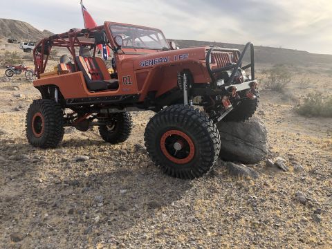 1992 Jeep Wrangler - Modified orange Jeep Wrangler with "GENERAL LEE" text and "01" on the fender, seen off-road with other vehicles.
