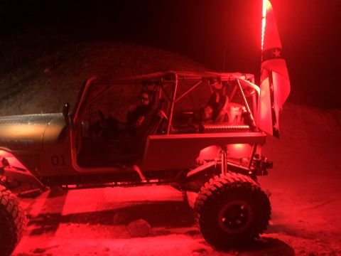 1992 Jeep Wrangler - This heavily modified Jeep is illuminated by red lights at night, with a flag mounted on the rear.