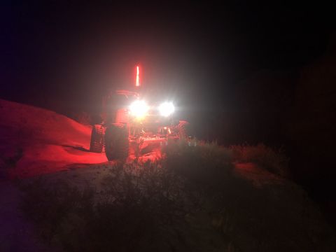 1992 Jeep Wrangler - An off-road vehicle is seen at night with its headlights and a red light bar illuminated.