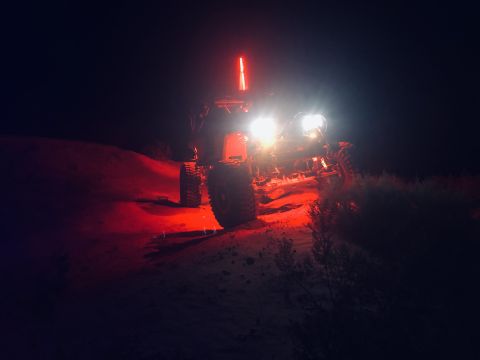 1992 Jeep Wrangler - Off-road buggy with lights on, navigating a dirt terrain in the dark.