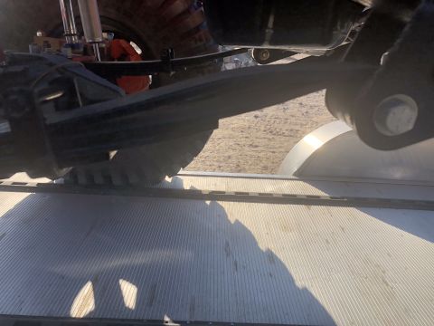 1992 Jeep Wrangler - The underside of a 1992 Jeep Wrangler is visible, showing its suspension and tire as it sits on a flatbed trailer.