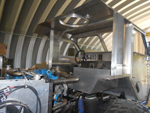 1992 Ford Bronco - The interior of a custom truck build shows an unfinished metal cab and exposed engine components.