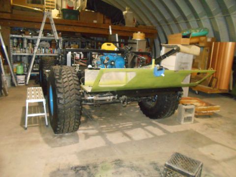 1992 Ford Bronco - This vehicle chassis is in a garage, showing its large tires and blue engine.