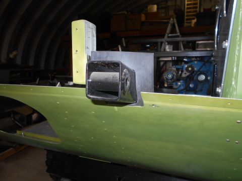 1992 Ford Bronco - A black tow hitch receiver is attached to the side of a green vehicle undergoing construction, with engine components visible in the backgr…