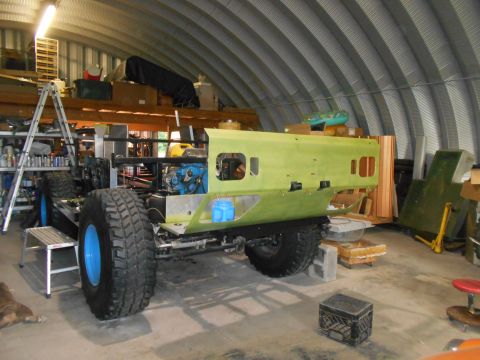 1992 Ford Bronco - This vehicle chassis is in a workshop, appearing to be under construction with large off-road tires.