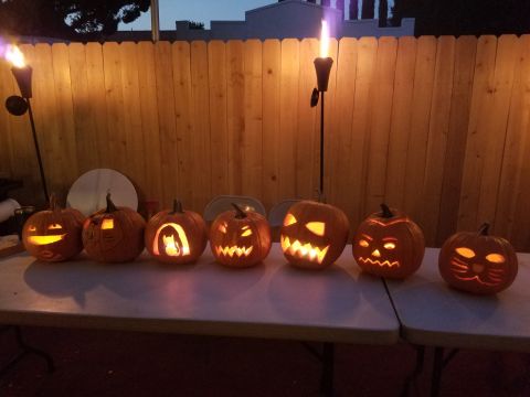 1990 Ford Bronco - Carved pumpkins with various spooky and cute faces are displayed on a table, illuminated from within.