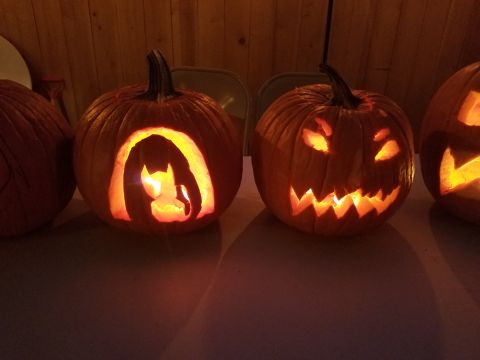 1990 Ford Bronco - Carved pumpkins, one a Batman silhouette and another with a classic jack-o'-lantern face, glow in the dark.