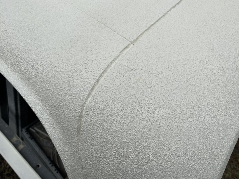 Textured light-colored vehicle body panel with a seam