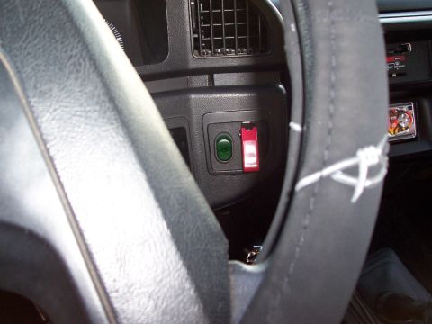 1990 Ford Bronco - Dashboard controls including a green button and a red toggle switch are visible inside the vehicle.
