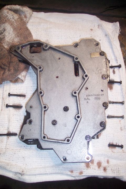 1973 Ford F-250 - A disassembled automatic transmission valve body is laid out on a white cloth with some oil stains and a brown rag. Several bolts are also…