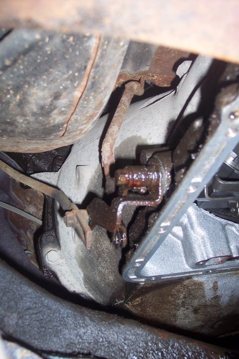 1973 Ford F-250 - This is a close-up, low-angle shot of the underside of a vehicle, focusing on mechanical components. Visible are rusted metal parts, likely…