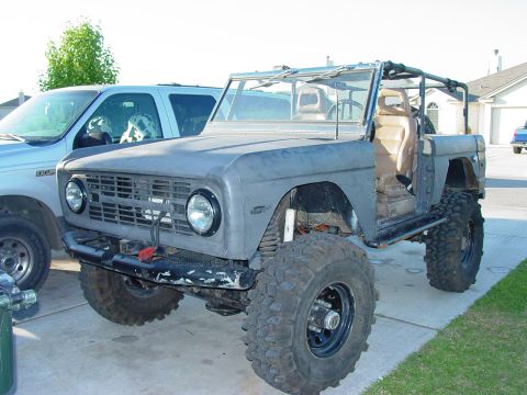 1972 Ford Bronco - A modified Ford Bronco sits in a driveway, showing its custom suspension and large tires.