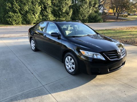 2011 Toyota Camry - Black sedan parked on a paved surface with trees in the background. Model year appears to be around 2007.