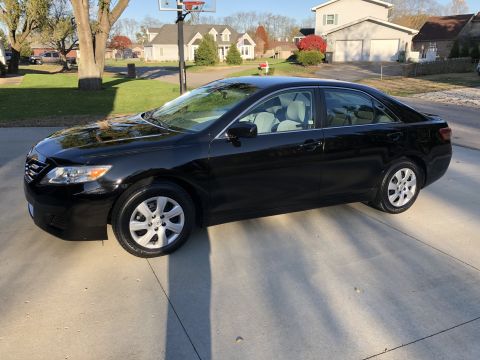 2011 Toyota Camry - This black 2011 Toyota Camry sedan is shown from the driver's side in a residential driveway.